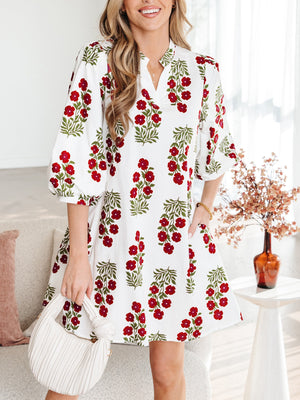 V-neck mini dress with pockets in white with red floral print, cotton fabric, and puff sleeves.