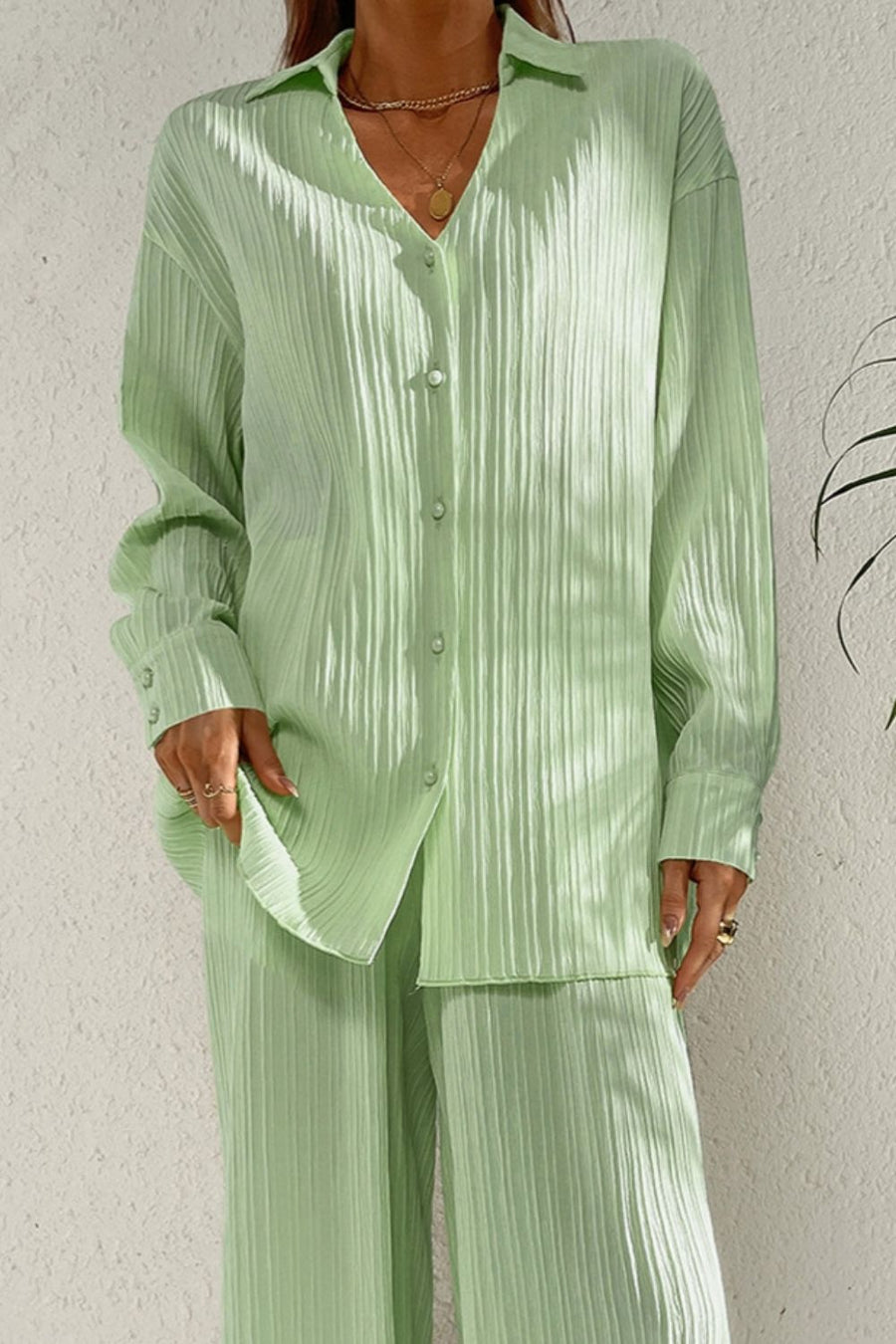 Pleated pastel blue co-ord set with button-down shirt and wide leg trousers.