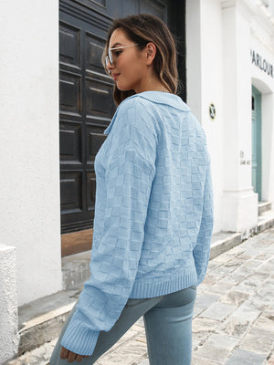 Light blue acrylic knit sweater with textured checkerboard pattern and polo neckline.