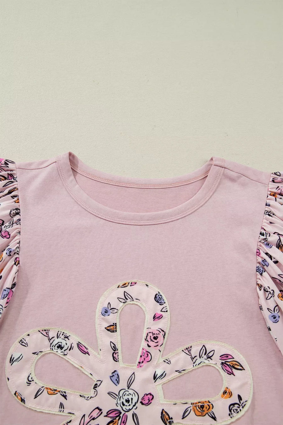 Pink cotton crew neck maternity shirt with floral patchwork sleeves and applique detail.