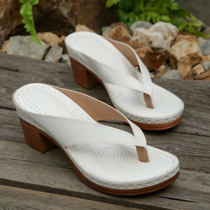 White toe-post block heel sandals with perforated insoles and wooden-look heels.