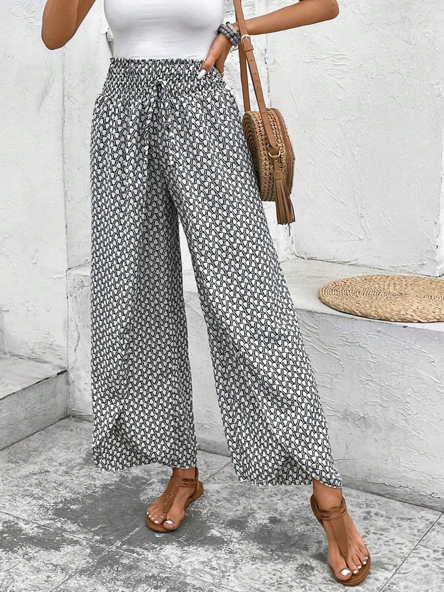 Palazzo pants with a black and white geometric print, elastic waist, and drawstring.