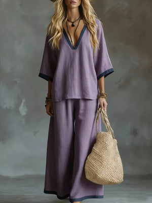 Purple V-neck two-piece set with contrast trim, wide-leg pants and short sleeves.