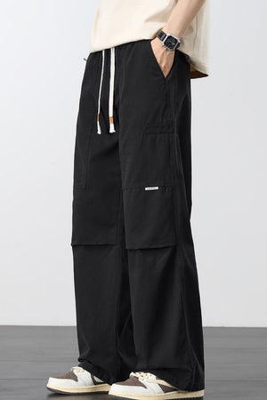 Black cargo pants with adjustable drawstring and multiple pockets.