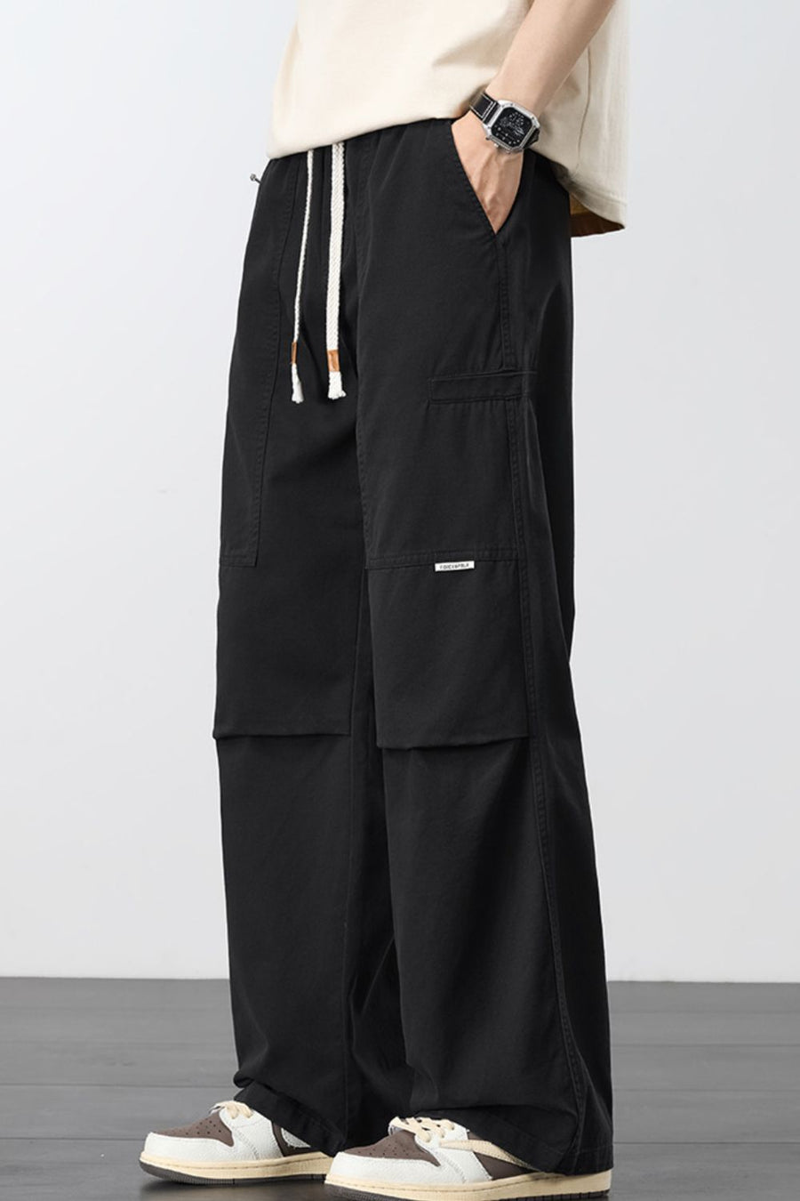 Black cargo pants with adjustable drawstring and multiple pockets.