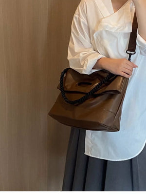 Oversized brown PU leather tote bag with braided handle detail.