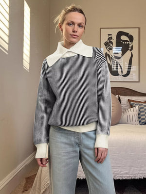 Striped knit sweater in black with a contrast white collar and cuffs.