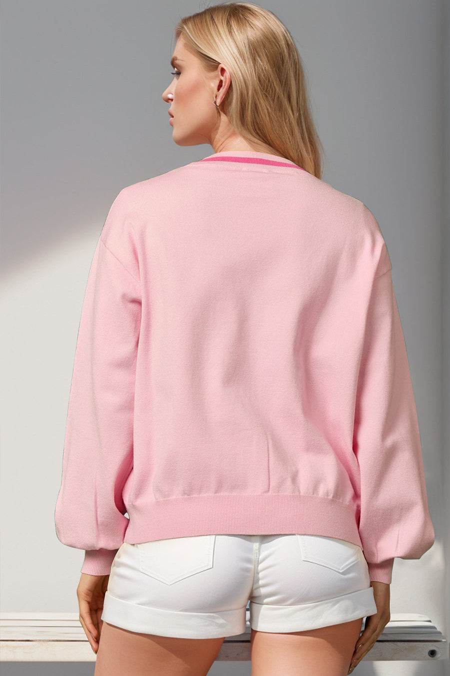 Blush pink acrylic cardigan with ribbed cuffs and neckline detail.