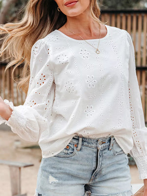 White cotton blouse with eyelet embroidery and ruffled sleeves.