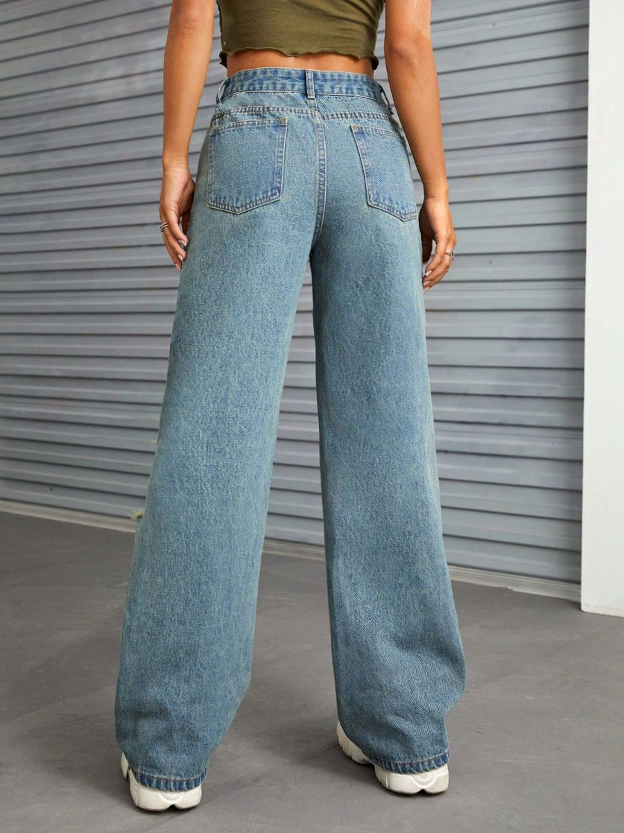 Distressed flare denim jeans in medium wash with raw edge detail and wide leg.