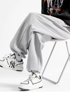Light gray cotton sweatpants with a relaxed fit and wide leg, cuffed at the ankle.