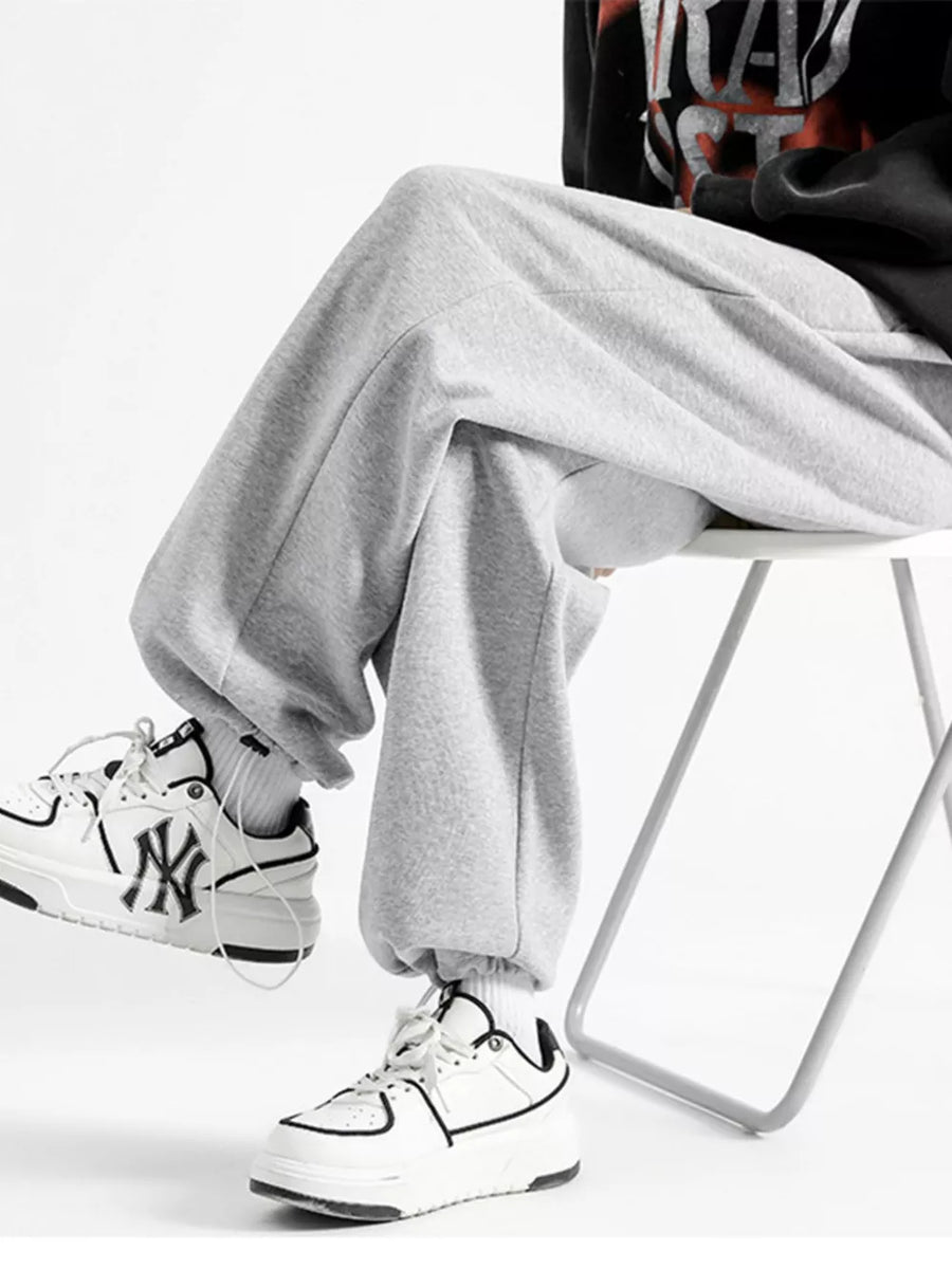 Light gray cotton sweatpants with a relaxed fit and wide leg, cuffed at the ankle.