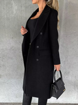Black double-breasted longline trench coat with button detail and lapel collar.
