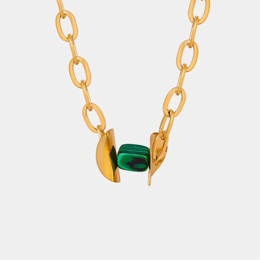 Geometric malachite pendant necklace with 18K gold-plated chain and abstract gold accents.