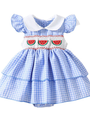 Baby dress in pastel blue gingham with fruit embroidery and ruffled sleeves.