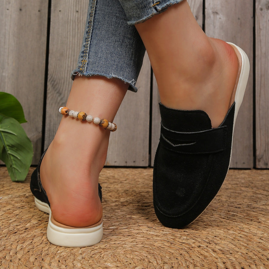 Black textured round toe slip-on loafers with a backless design and white sole.