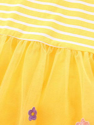 Yellow striped cotton dress with yellow tulle skirt featuring embroidered flowers.