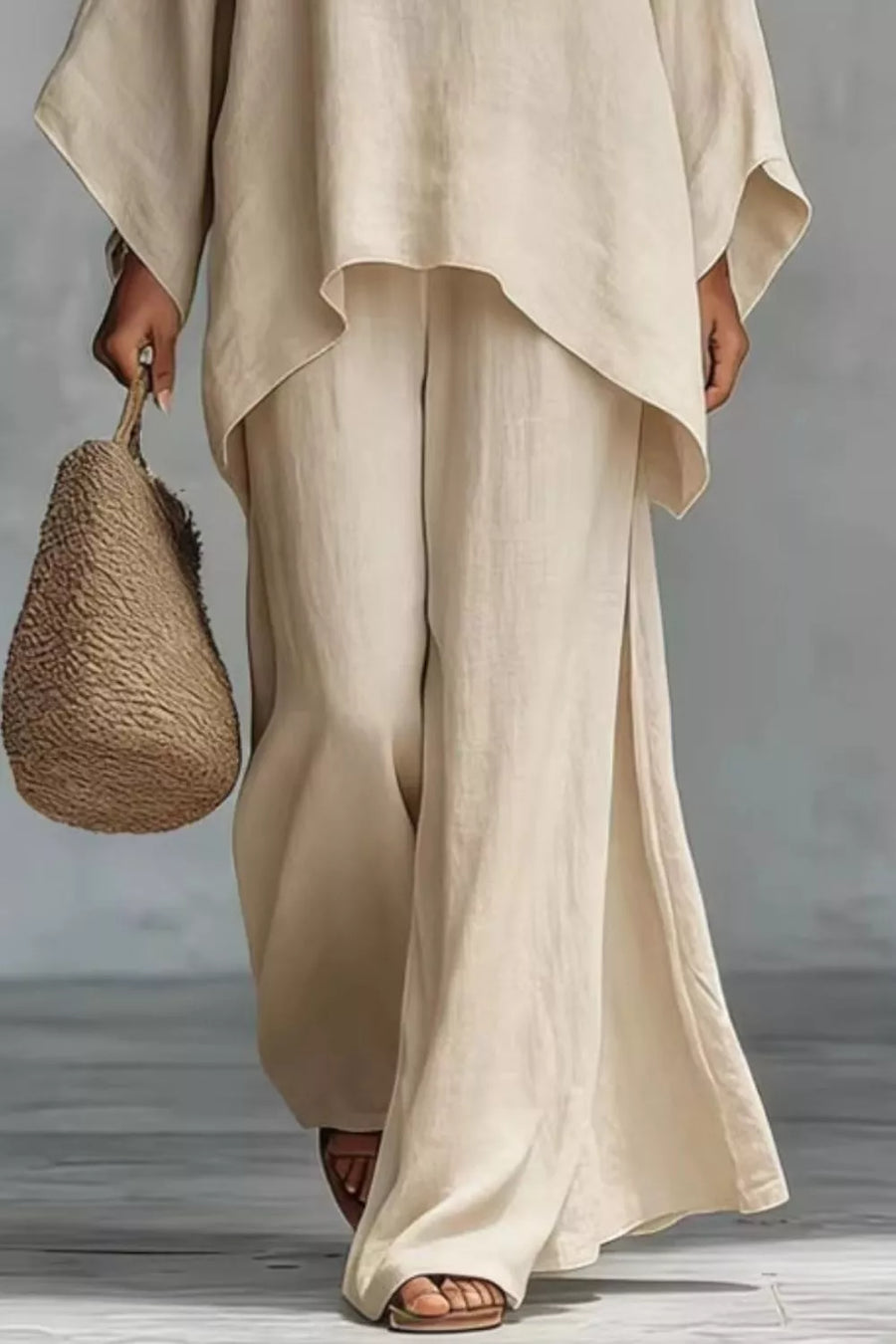 Beige polyester two-piece set with flowing top and wide-leg pants with side slits.