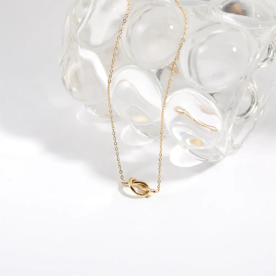 Gold knot pendant necklace with delicate chain, 18K gold-plated.