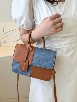 Chic two-tone PU leather crossbody bag in brown and denim blue with a decorative tag.
