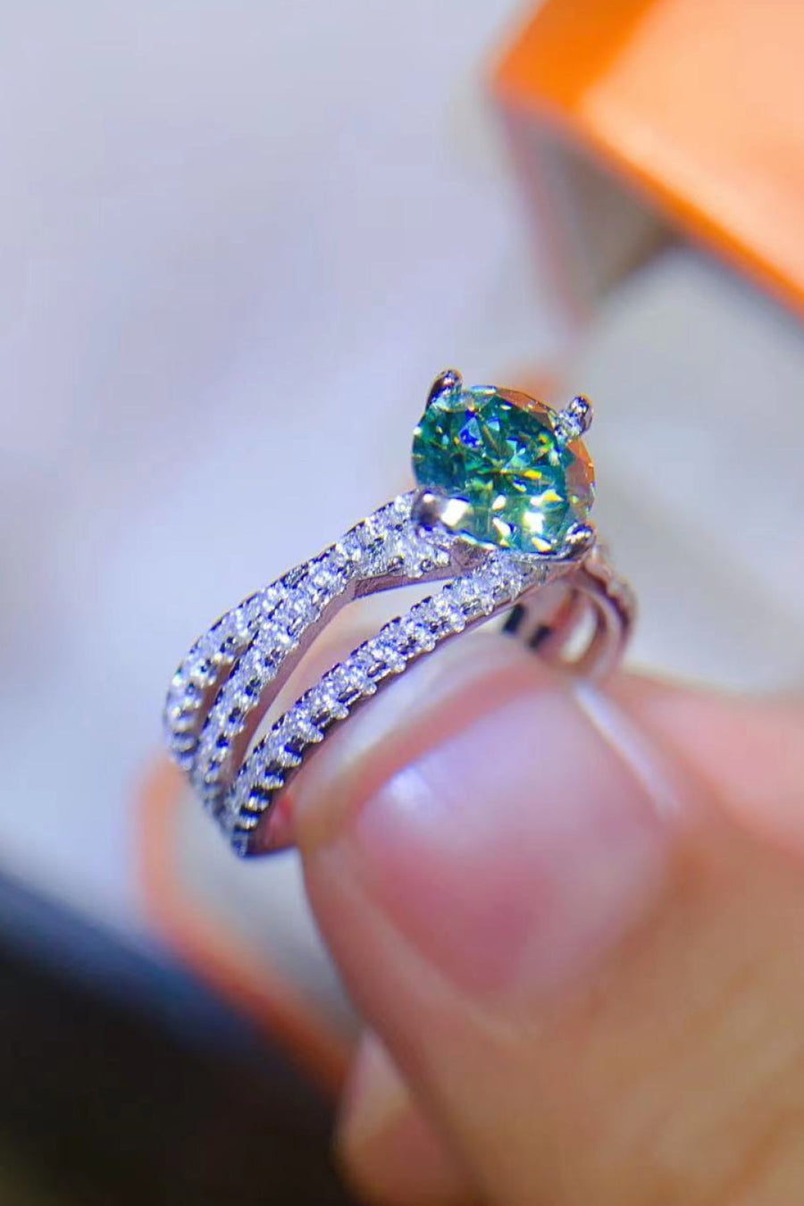 Twisted pavé halo ring with light green stone and sterling silver band.