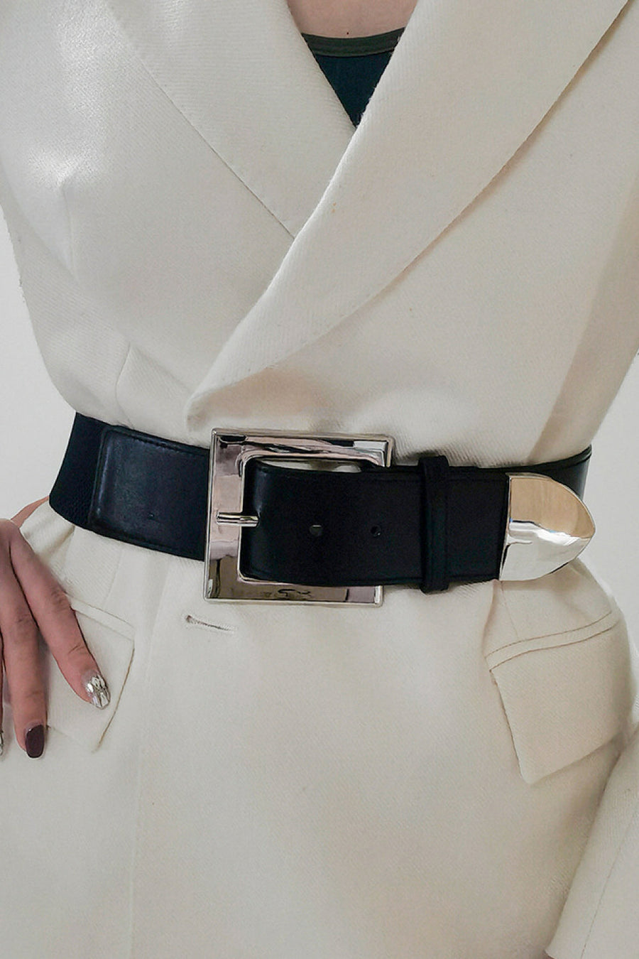 Black faux leather belt with a bold silver sculpted buckle and tip.