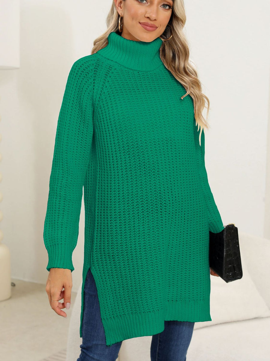 Dark green knit turtleneck sweater with asymmetric hemline and side slits.