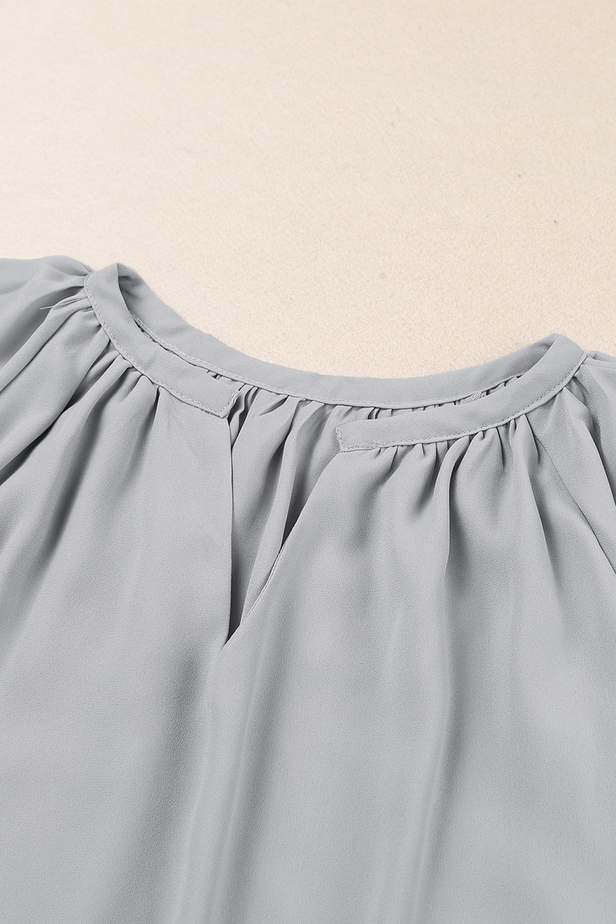 Gray relaxed V-neck blouse with gathered neckline and cap sleeves