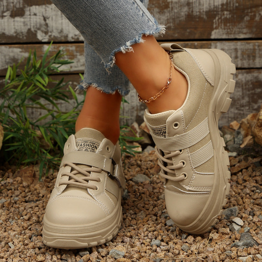 Beige lace up platform sneakers with chunky sole and side strap detail.