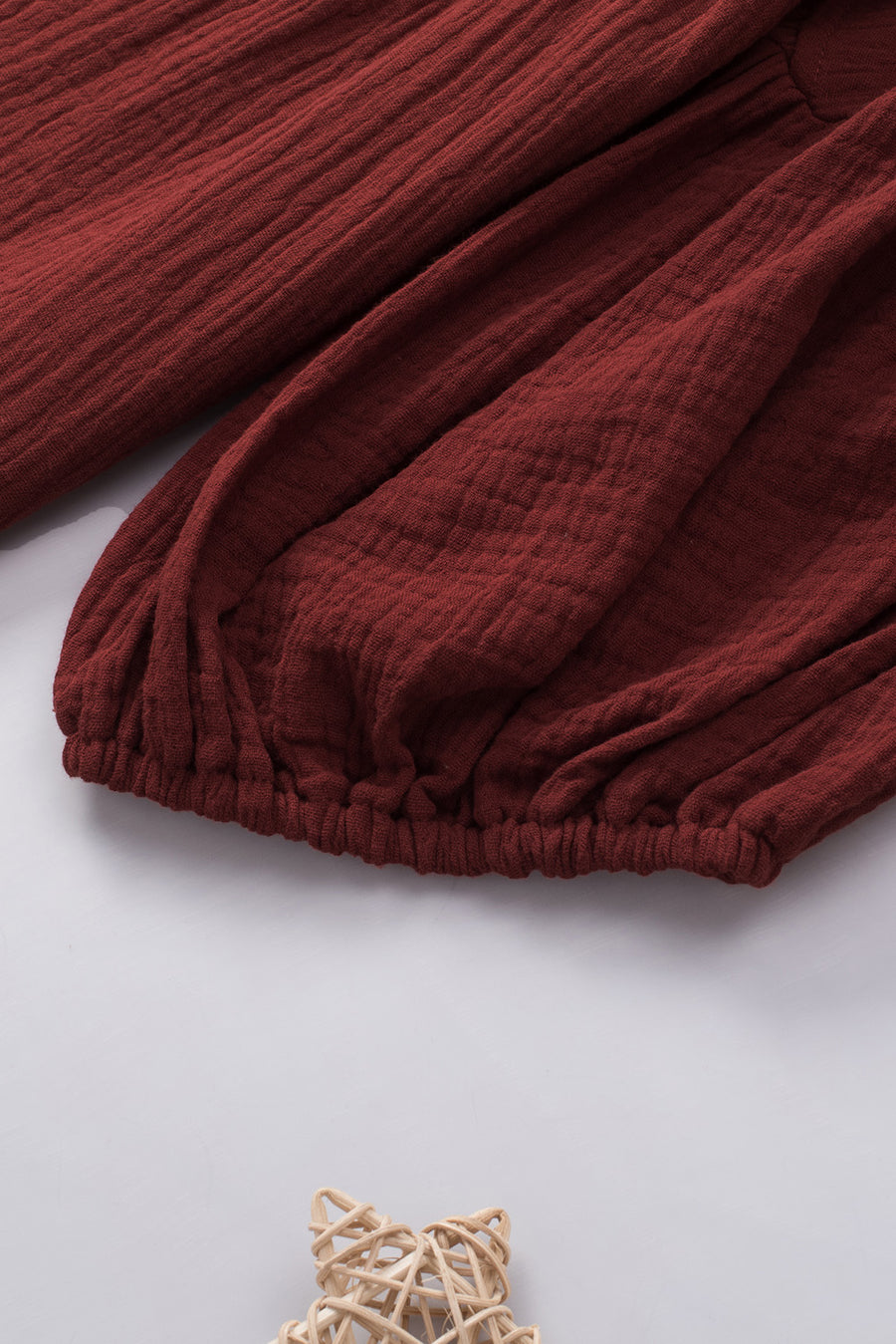 Textured gauze blouse in wine with gathered sleeves and elastic hem detail.