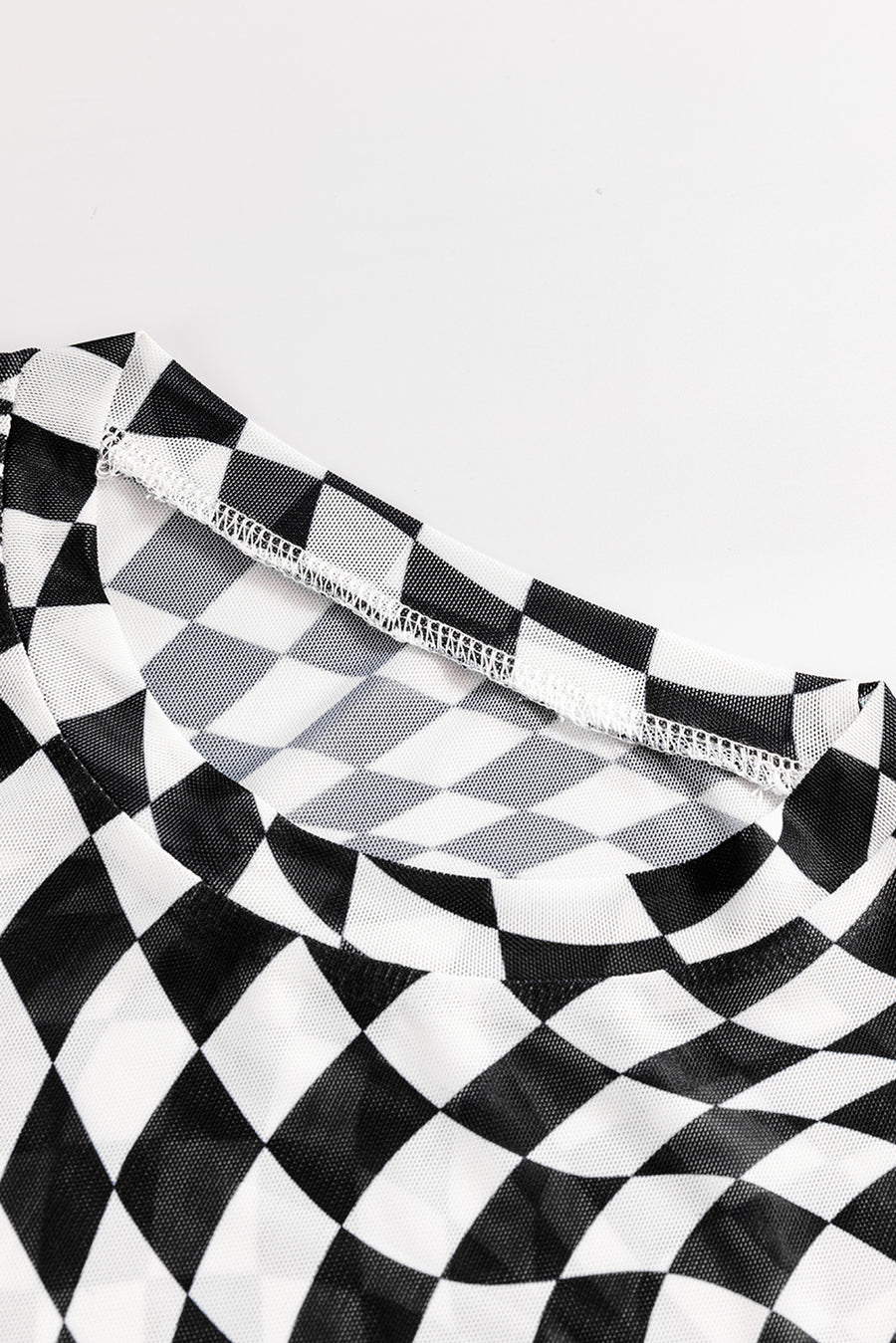 Black and white checkered mesh blouse with a crew neck and visible stitching detail.