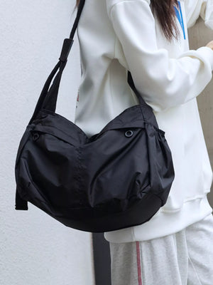 Spacious black nylon crossbody bag with adjustable strap and exterior pockets.