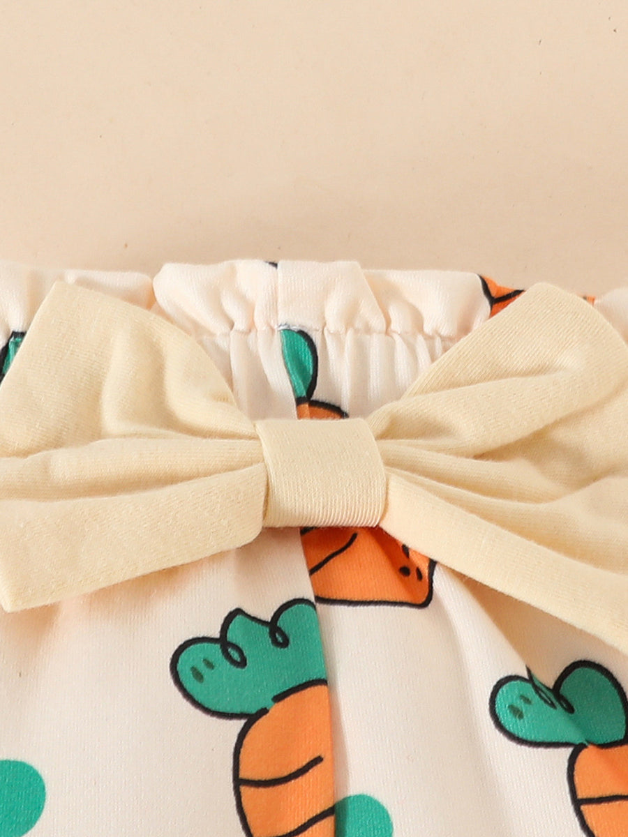 Baby set with cream fabric, carrot print, and a pale yellow bow detail.