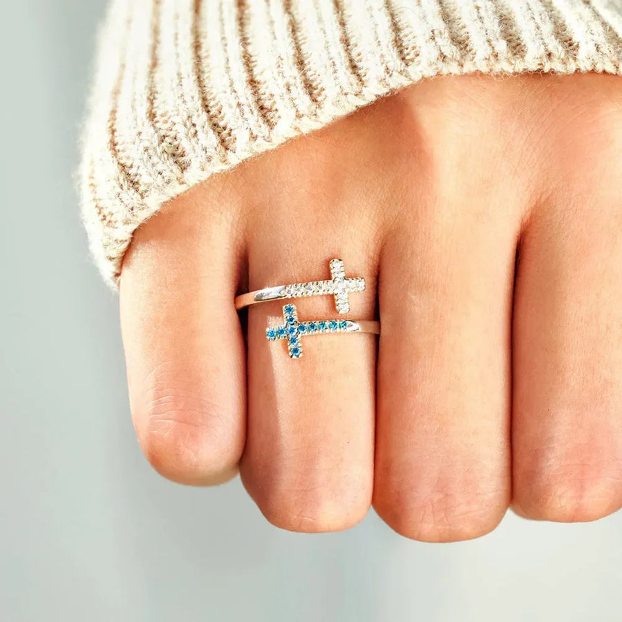 Sterling silver ring with two intertwined crosses, one with clear stones and one with blue stones.