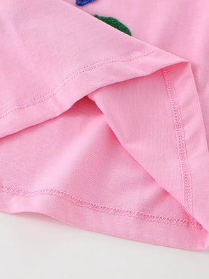 Pink cotton t-shirt with embroidered ocean creature detail and visible stitching.