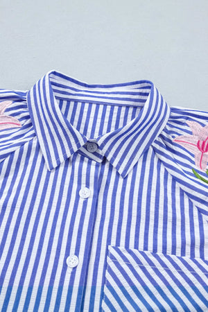 Blue and white striped button-down blouse with floral embroidery and a pocket.