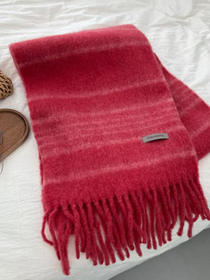 Red striped scarf with fringe hem and soft fuzzy texture.