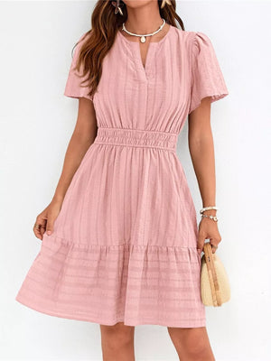 Pink textured V-neck tiered dress with smocked waist and short sleeves