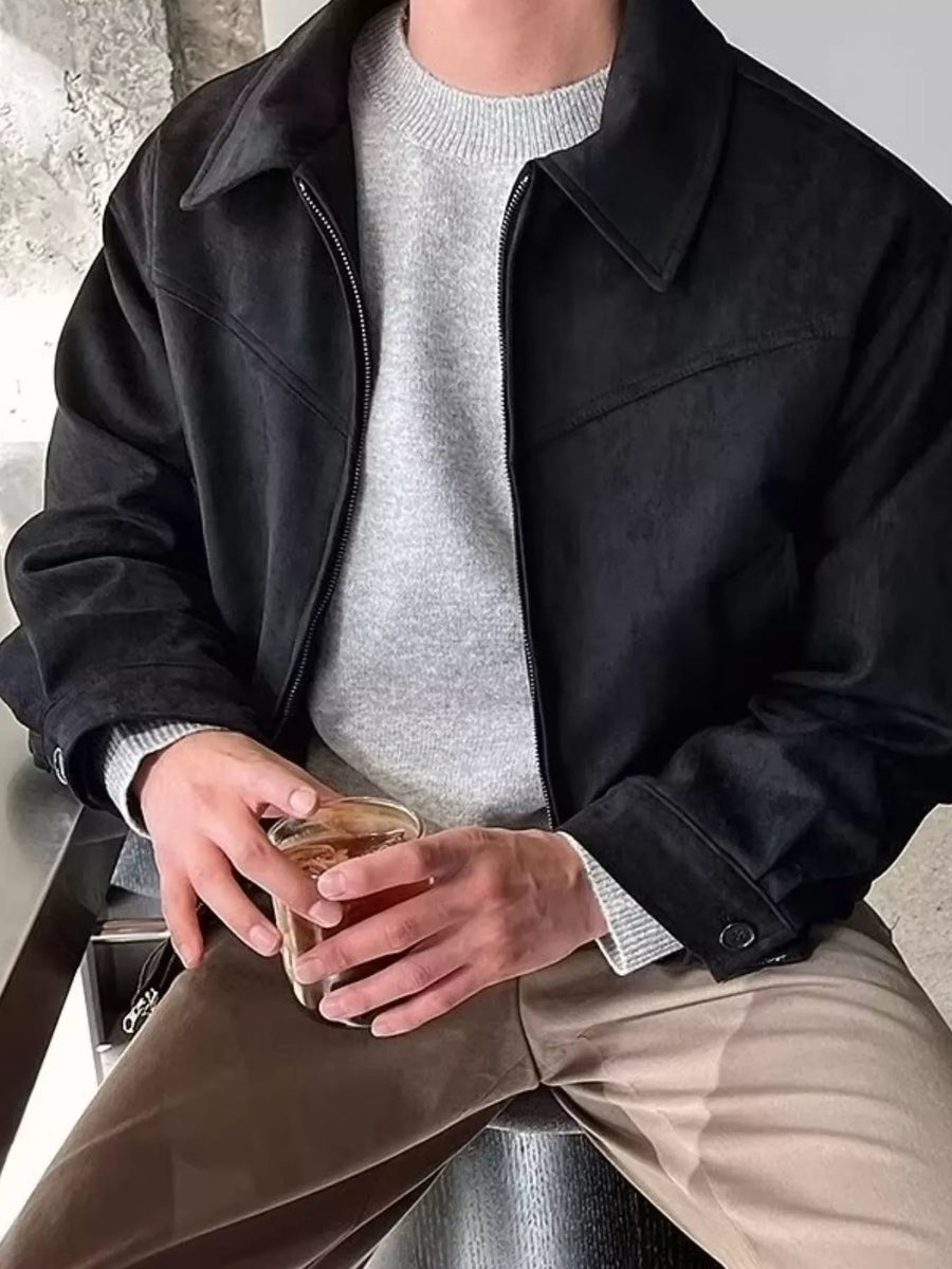 Black casual zip-up jacket with collar and button cuffs, styled over a grey sweater.
