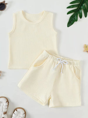 Soft ribbed baby tank top and shorts set in cream with drawstring waist and pockets.