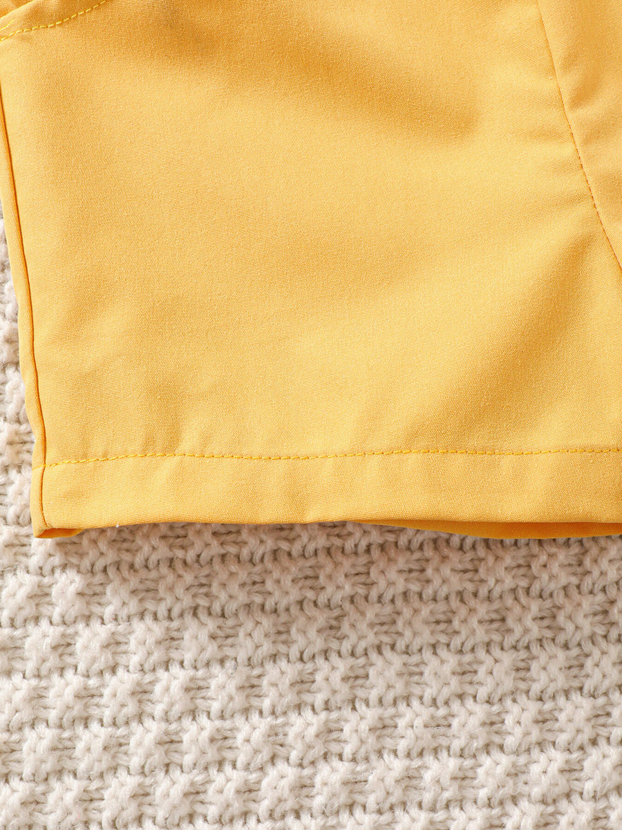 Yellow baby set detail with tropical print and bow tie accent