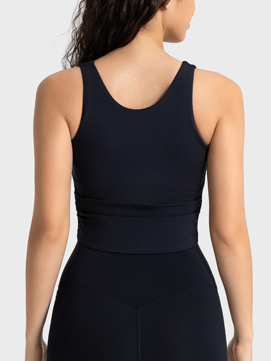 Black athletic tank top with ruched detail at the waist and a scoop neckline.