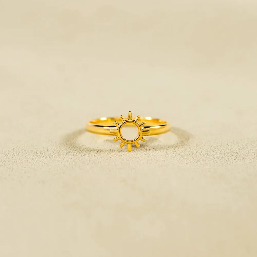 Gold sunburst signet ring with a cut-out center detail.
