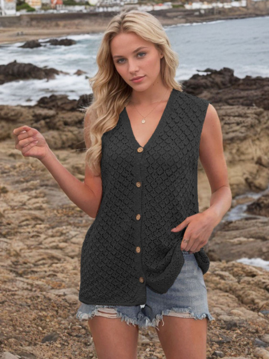 Black openwork knit vest with V-neck and button front, styled with denim shorts.