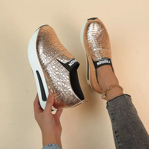 Gold metallic crocodile-embossed platform sneakers with chunky sole and black "FASHION" detail
