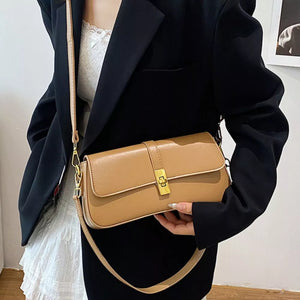 Taupe rectangular crossbody bag with gold clasp and adjustable strap.