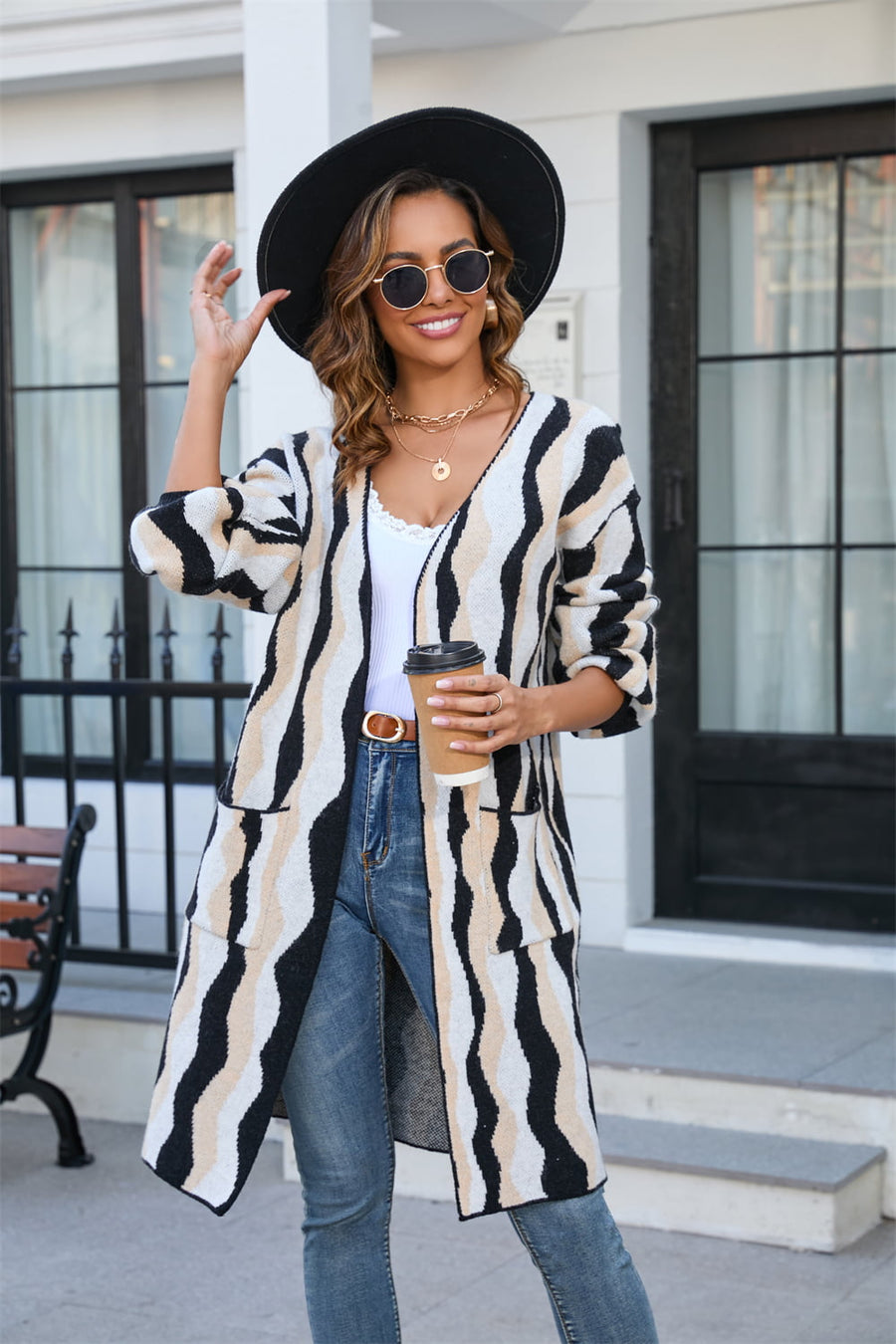 Longline knit cardigan with wave stripe pattern in black and tan, featuring pockets and an open front.