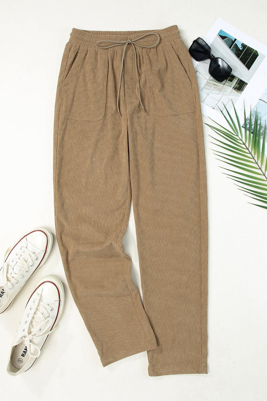 Khaki corduroy drawstring trousers with slant pockets and a relaxed fit.