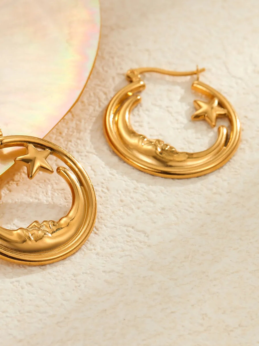 Gold earrings featuring crescent moon design and celestial