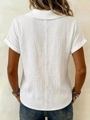 White textured blouse with short rolled sleeves and collared neckline.